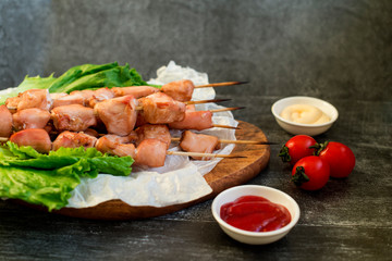 Chicken breast skewers cooked in homemade oven with red and white sauce and tomatoes.