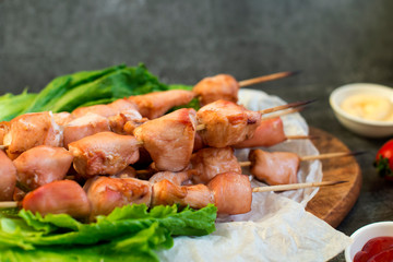 Chicken breast skewers cooked in homemade oven with red and white sauce and tomatoes.