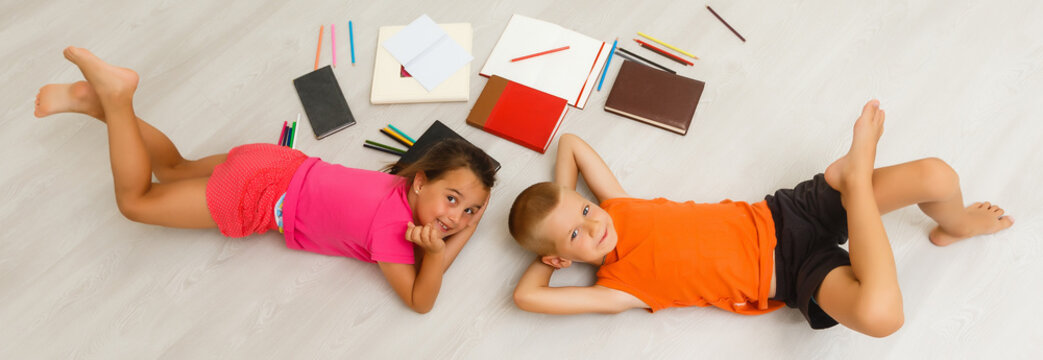 Two children, little girls of preschool age watching tablet at home on the floor