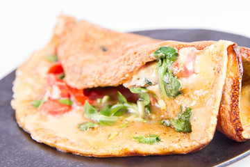 Omelette with tomatoes and fresh corn salad on a white background