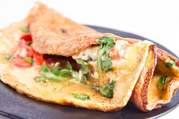 Omelette with tomatoes and fresh corn salad on a white background