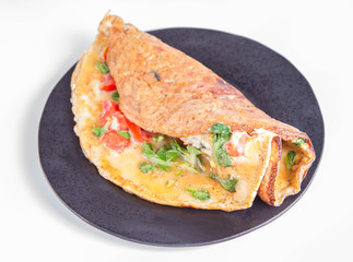 Omelette with tomatoes and fresh corn salad on a white background