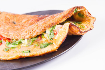 Omelette with tomatoes and fresh corn salad on a white background
