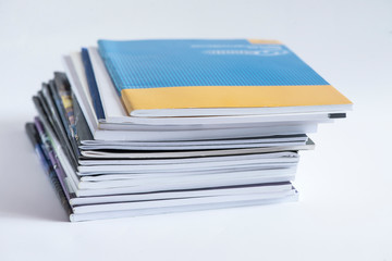 Pile of advertising magazines on a white background.