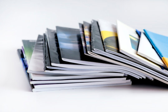 Pile of advertising magazines on a white background.