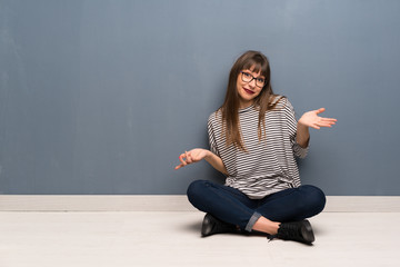 Woman with glasses sitting on the floor unhappy because not understand something