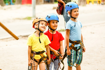 Children - a boy and a girl in the rope park pass obstacles. Brother and sister climb the rope road