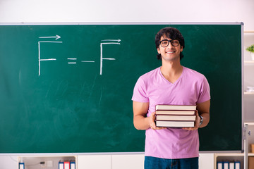 Young male physic standing in front of the green board