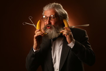 Portrait of a gray-haired elderly gentleman, with a shaggy mustache and beard, in a white shirt and gray jacket, wearing glasses and a fork