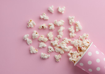 Spilled popcorn on a pink background, cinema, movies and entertainment concept