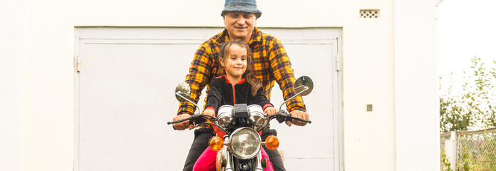 Happy grandfather and his granddaughter in handmade sidecar bike smiling