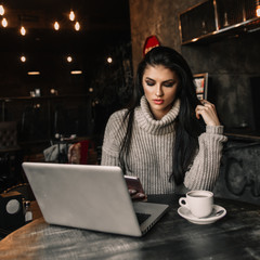 Beautiful woman working with laptop in a cafe.