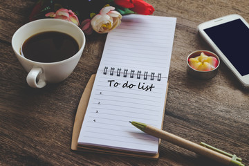 To Do List text on book note with cup of coffee, pen and smartphone.