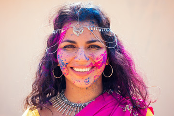 Portrait of young Indian face in paint Woman in traditional indian pink outfit with jeweler...