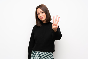 Young woman over white wall happy and counting three with fingers