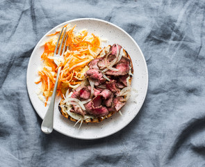 Medium rare beef steak ciabatta sandwiches with pickled asian style cabbage and homemade mayonnaise mustard sauce on grey background, top view