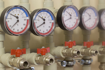 A number of identical manometers stand on plastic pipes with red valves