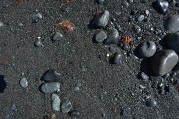 image of black sand with stones