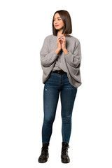A full-length shot of a Young woman scheming something over isolated white background