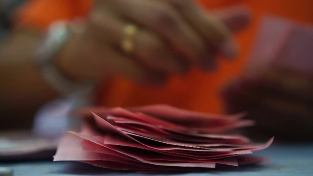 Businesswoman's hands counting money banknotes Thai baht bills at a table in bank or store front. (THB) is the official currency of Thailand, slow motion