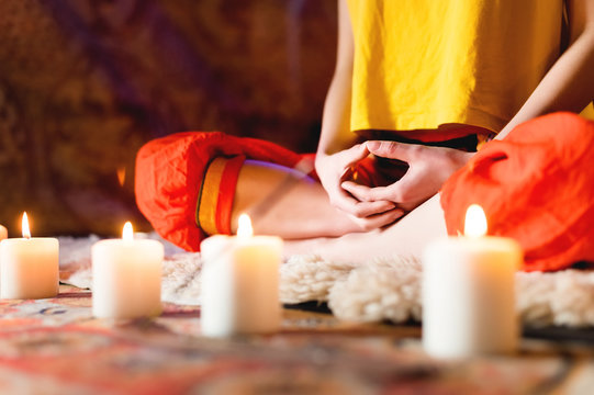 Close-up Of Woman's Hand In Yoga Lotus Pose Meditating In A Crafting Room With Candles