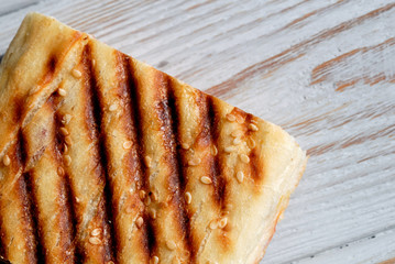Grilled toast sprinkled with sesame seeds top view closeup. Shallow depth of field