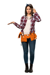 A full-length shot of a Young worker woman making the gesture of madness putting finger on the head over isolated white background