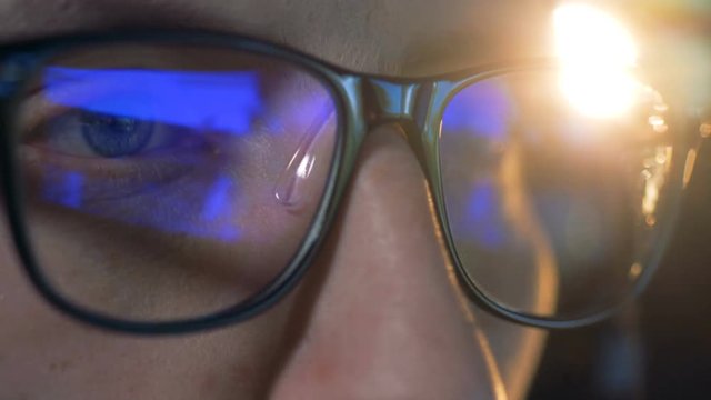 Close up of glasses put on a man with a computer game reflecting in them