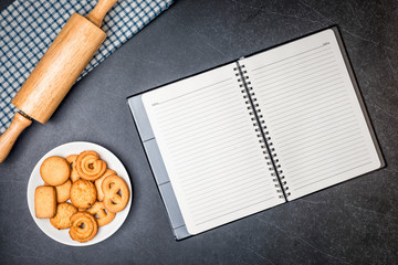 Cookies on Plate and Diary book with Black stone table background.