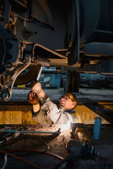 mechanic repairing car suspension