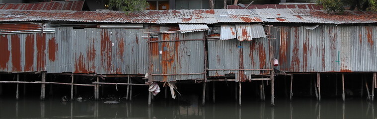 Zinc house a shabby old dilapidated corrugated iron building on the water. Bangkok, Thailand