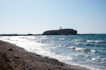 The Apollo Temple in Naxos, Greece in the distance, the ocean and the sore in the front