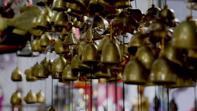 Beautiful crafted bells on a string wind chimes in souvenir shop multiple. Shiny with light flare