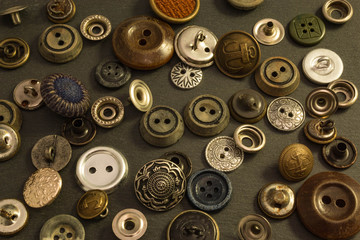Collection of vintage clothing buttons. Dark stone background, grunge photo.