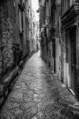 Fototapeta na wymiar Naples, Italy - August 16, 2015 : Narrow streets of Naples, black and white photographs.