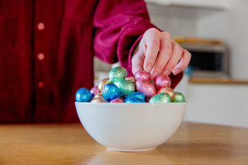 female hands try to take Easter eggs in plate