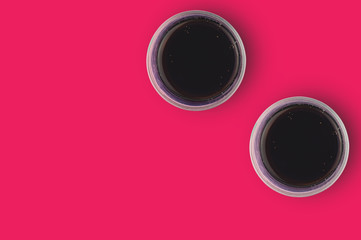 Pair of full glasses of aerated cola with bubbles on red table in cuisine. Copy space for your text. Top view. Rest concept