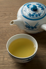 Cup with Japanese green tea and teapot