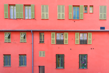 Fototapeta na wymiar Nice, France, colorful red facade, with typical windows and shutters 