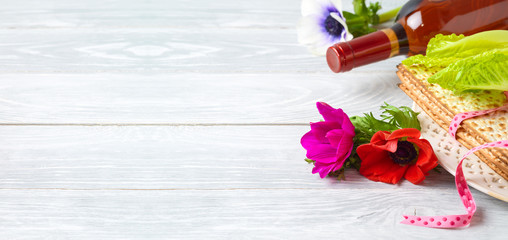 Jewish holiday Passover background with flowers, wine and matzo on wooden table