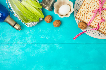Jewish holiday Passover background with matzo, seder plate and wine on wooden table.