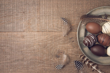 Easter holiday background with brown easter eggs decorations on wooden table.