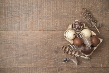 Easter holiday background with brown easter eggs decorations on wooden table.