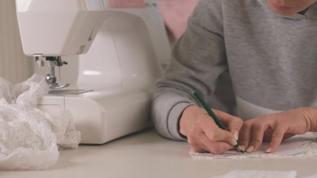 Proffesional seamstress making pettern with pencil