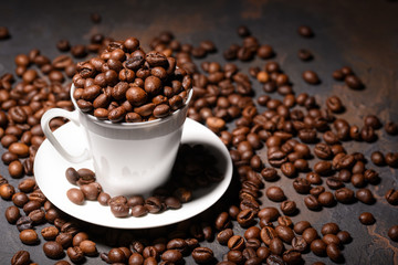 Coffee beans in coffee cup on black background