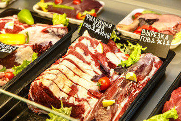 Pieces of beef and lamb are on the counter in the market.