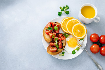 Breakfast of eggs with bruschetta tomatoes and orange juice top view