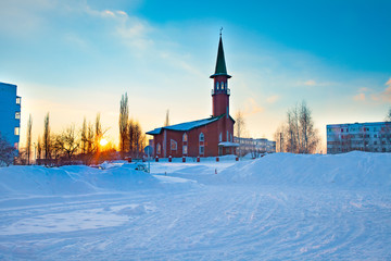 A small mosque of red brick. Winter. Sunset