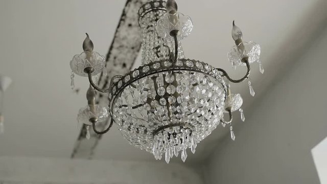 Luxury large crystal chandelier hanging. Vintage lighting lamps with light bulbs.