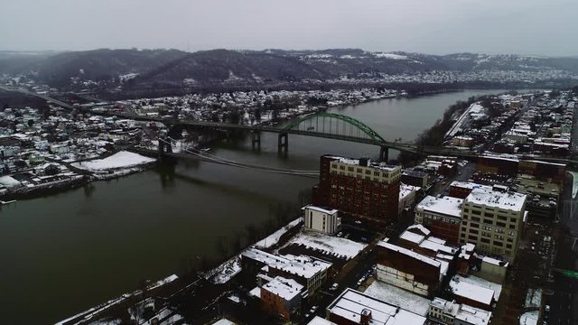 Aerial: Snowy Orbit over Wheeling, West Virginia Bridges.